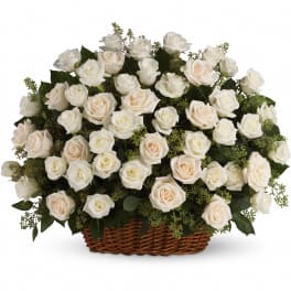 Large arrangement of ivory and white roses in a brown wicker basket