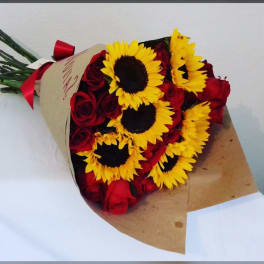 Bouquet of red roses and yellow sunflowers wrapped in brown paper