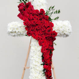 Red rose cross with white flowers on a wooden easel