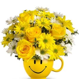 Yellow roses and daisies in a smiley-face mug