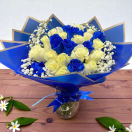 Bouquet of blue and cream roses wrapped in blue paper