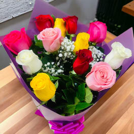 Bouquet of multicolored roses wrapped in purple paper