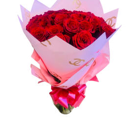 Bouquet of red roses wrapped in pink paper with a ribbon