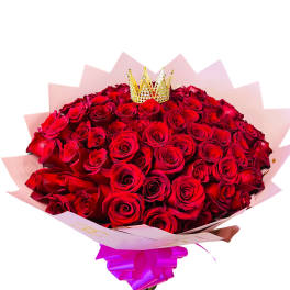 Bouquet of red roses with a small crown topper and pink wrapping