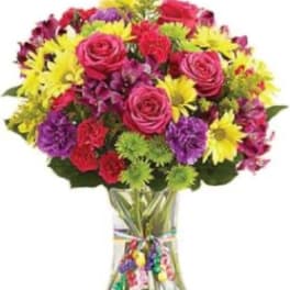 Colorful bouquet of roses, daisies, and carnations in a clear glass vase