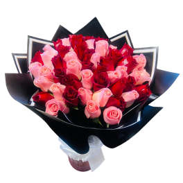 Bouquet of pink and red roses wrapped in black paper