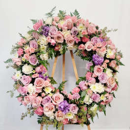Large pastel floral wreath on a wooden easel