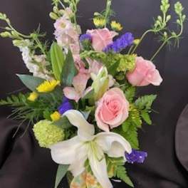 Bouquet of pink roses, white lilies, and purple accents