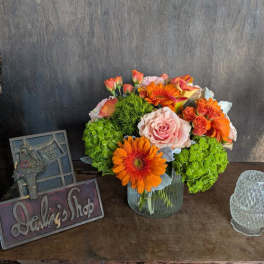 Bouquet of orange and pink flowers in a glass vase