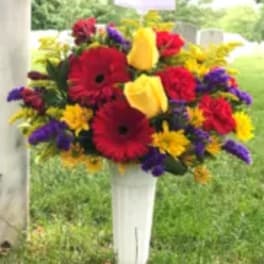 Colorful mixed flower arrangement in a white pedestal vase