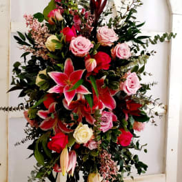 Tall floral spray with pink roses and lilies on a stand