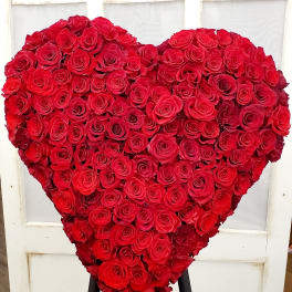 Heart-shaped arrangement of red roses on a stand