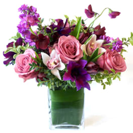 Pink and purple flower arrangement in a clear glass vase