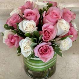 Pink and white roses arranged in a glass vase