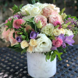 Bouquet of pink, white, and purple flowers in a white vase