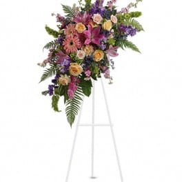 Tall floral spray on a white easel with pink, purple, and yellow blooms