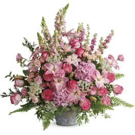 Pink roses and lilies arranged in a gray vase