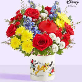 Colorful bouquet of roses, chrysanthemums, and blue flowers in a Disney Mickey and Friends container
