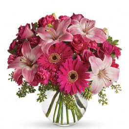 Pink lilies and gerbera daisies in a clear glass vase