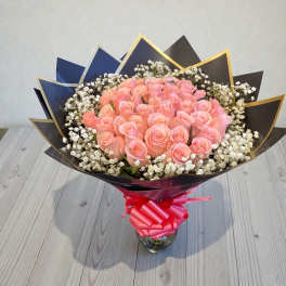 Bouquet of pink roses with white baby's breath in a glass vase