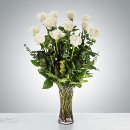 Tall bouquet of white roses in a clear glass vase