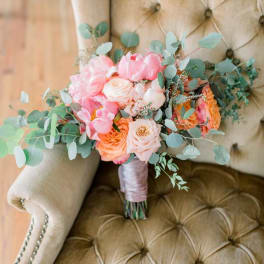 Pink and peach bouquet with eucalyptus on a chair