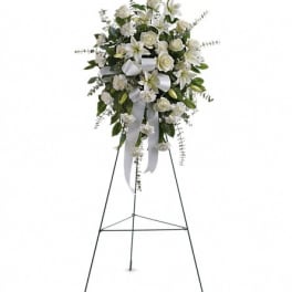 White floral standing spray on an easel with ribbon