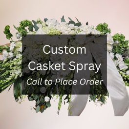 White casket spray with ribbon and mixed greenery