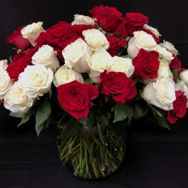 Red and white roses arranged in a clear glass vase