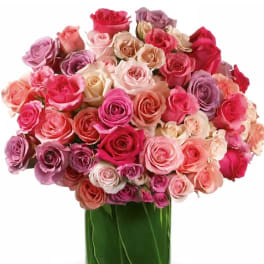 Bouquet of pink, peach, and lavender roses in a glass vase