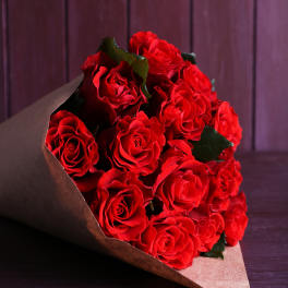 Bouquet of red roses wrapped in brown paper
