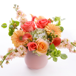 Pink and peach flower arrangement in a round vase