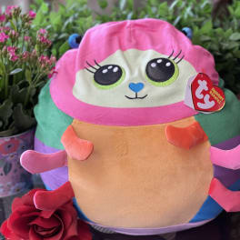 Plush toy with a red rose in front of potted flowers
