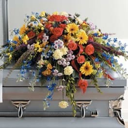 Large colorful floral casket spray with roses and daisies