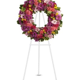 Colorful mixed flower wreath on a white easel stand