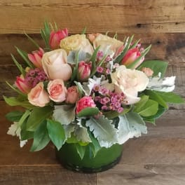 Pink and cream roses with tulips in a green vase