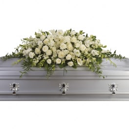 Long white rose and calla lily casket spray on a silver casket
