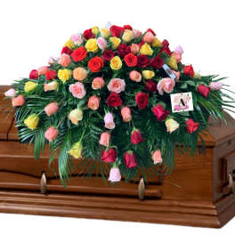 Casket spray of multicolored roses with cascading greenery