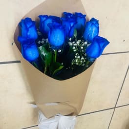 Bouquet of blue roses wrapped in brown paper with a white ribbon