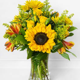 Yellow sunflower and rose bouquet in a clear glass vase