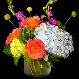 Colorful bouquet with roses and hydrangeas in a glass vase