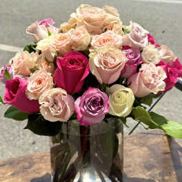 Bouquet of pink and peach roses in a clear glass vase