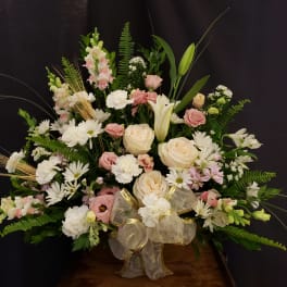 Large pastel floral arrangement with roses, lilies, and daisies in a basket