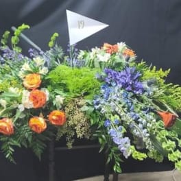 Large floral arrangement with orange roses and purple flowers