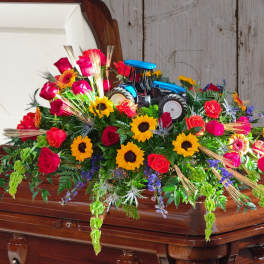Colorful floral casket spray with a toy tractor centerpiece