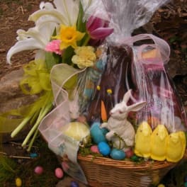 Basket of lilies and Easter candy with a rabbit figurine