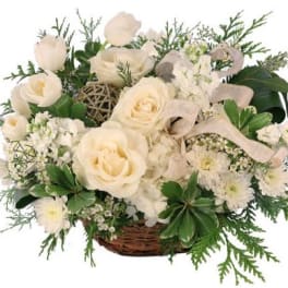 White roses and small white flowers in a wicker basket