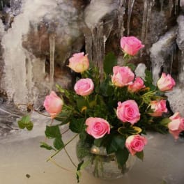 Pink roses arranged in a clear glass vase