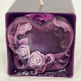 Purple square candle with a heart-shaped floral decoration