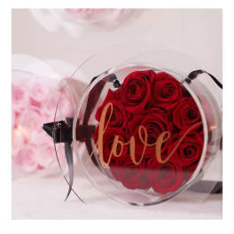 Round clear box of red roses with a "love" label